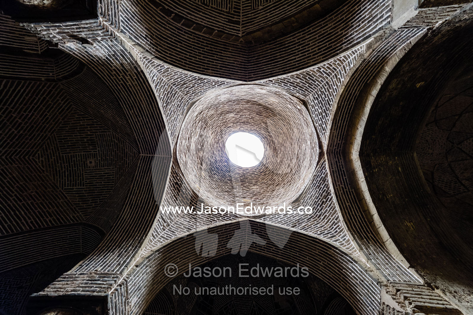 The vaulted ceiling and skylight of a dome in the Jameh Mosque above large pillars. Jameh Mosque of Isfahan, Isfahan, Isfahan Province, Islamic Republic of Iran.