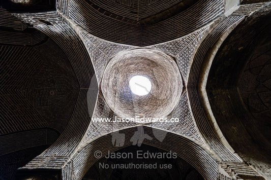The vaulted ceiling and skylight of a dome in the Jameh Mosque above large pillars. Jameh Mosque of Isfahan, Isfahan, Isfahan Province, Islamic Republic of Iran.