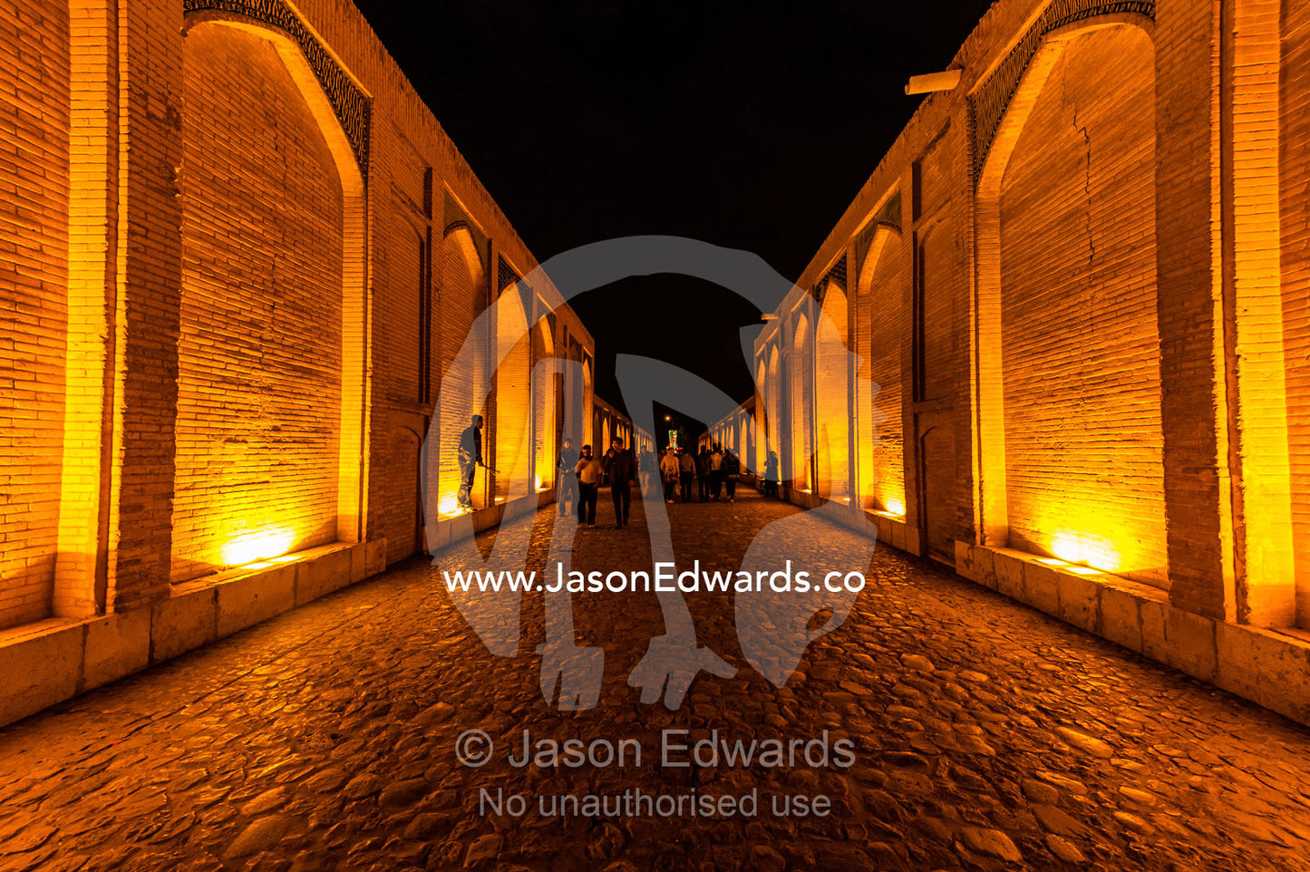 Light cascades from iwans lining the Khaju Bridge onto families and friends celebrating Nowruz Iranian New Year. Khaju Bridge, Isfahan, Isfahan Province, Islamic Republic of Iran.