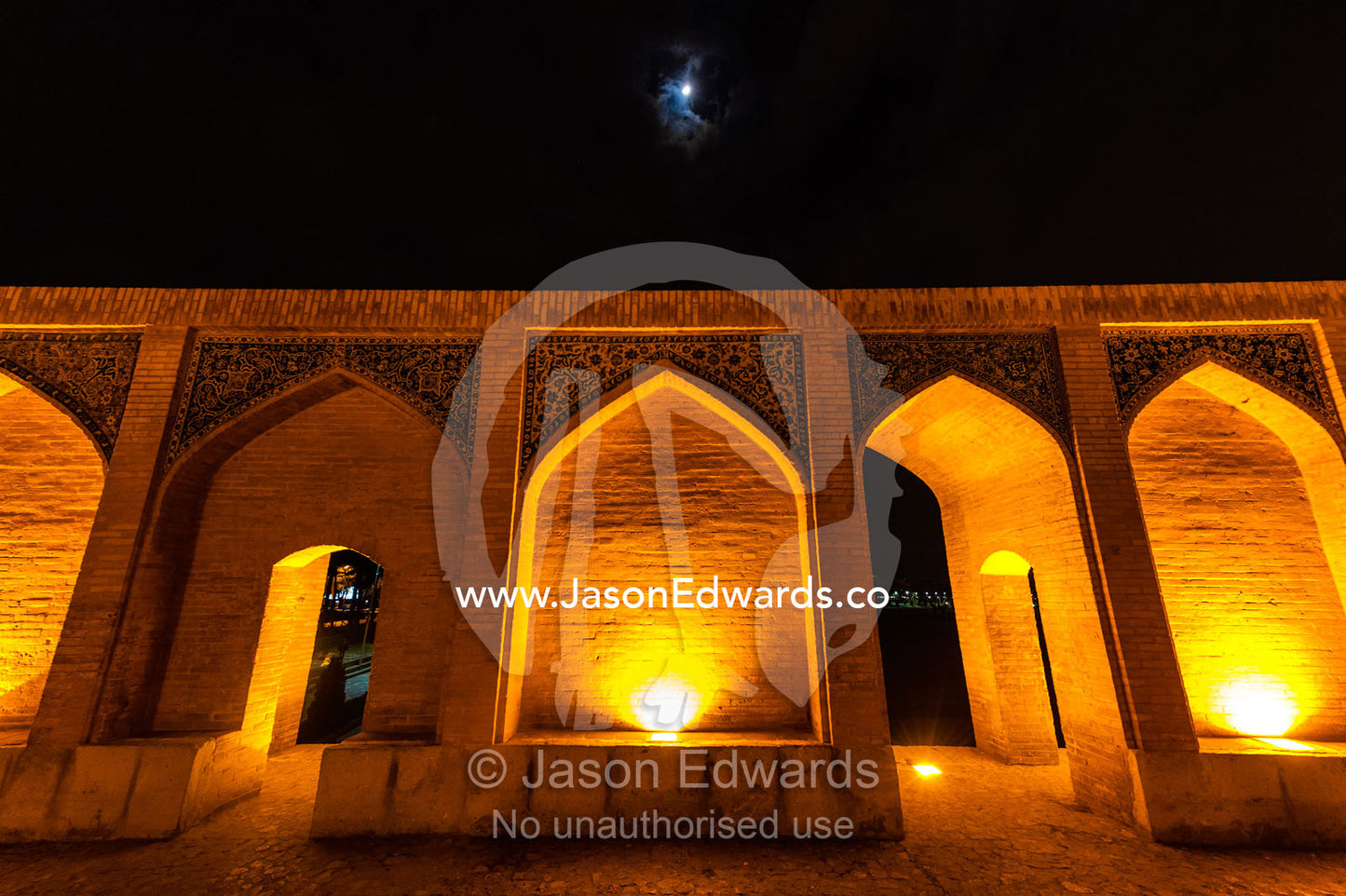 Light cascades from iwans lining the Khaju Bridge at night during Nowruz Iranian New Year. Khaju Bridge, Isfahan, Isfahan Province, Islamic Republic of Iran.