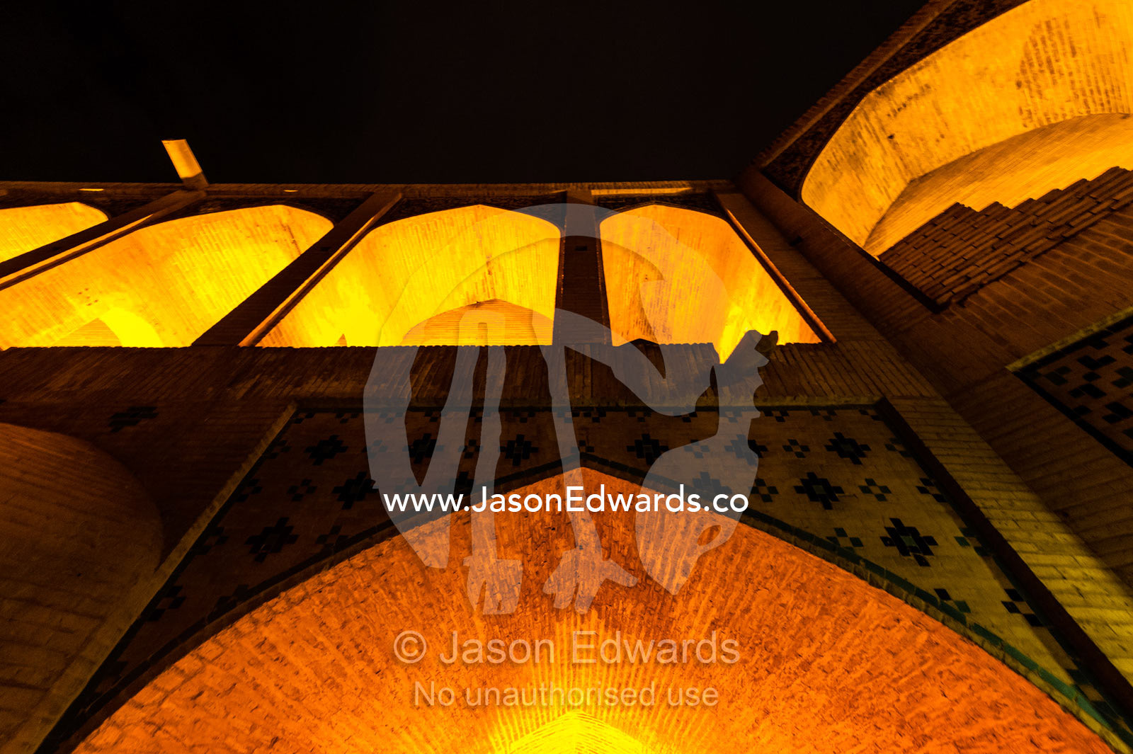 Light cascades from iwans lining the Khaju Bridge at night during Nowruz Iranian New Year. Khaju Bridge, Isfahan, Isfahan Province, Islamic Republic of Iran.