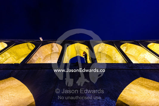 Light cascades from iwans lining the Khaju Bridge at night during Nowruz Iranian New Year. Si-o-seh pol Bridge, Zayandeh River, Isfahan, Isfahan Province, Islamic Republic of Iran.