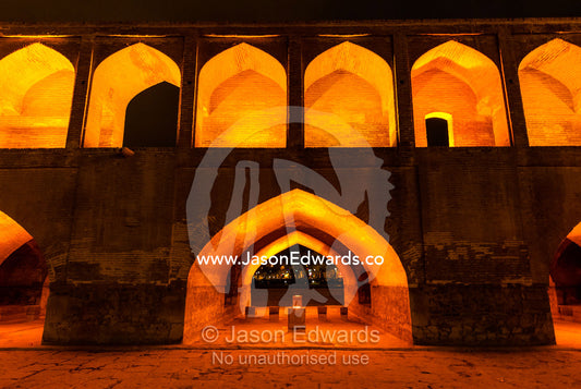 Light cascades from iwans lining the Khaju Bridge at night during Nowruz Iranian New Year. Si-o-seh pol Bridge, Zayandeh River, Isfahan, Isfahan Province, Islamic Republic of Iran.