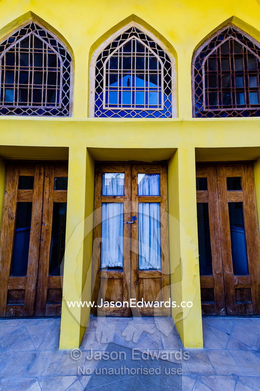 Arched pane glass windows in a canary yellow wall of a traditional house. Dibai house, Isfahan, Isfahan Province, Islamic Republic of Iran.