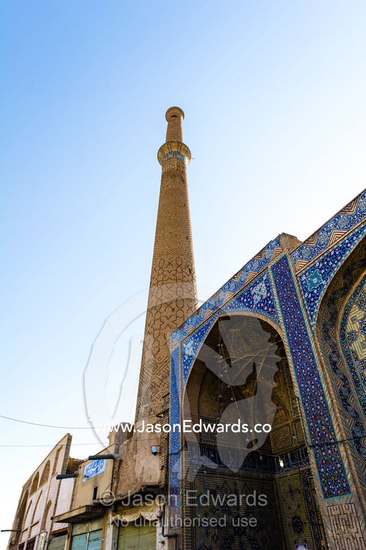 A minaret towers over the entrance to a Mosque. Isfahan, Isfahan Province, Islamic Republic of Iran.