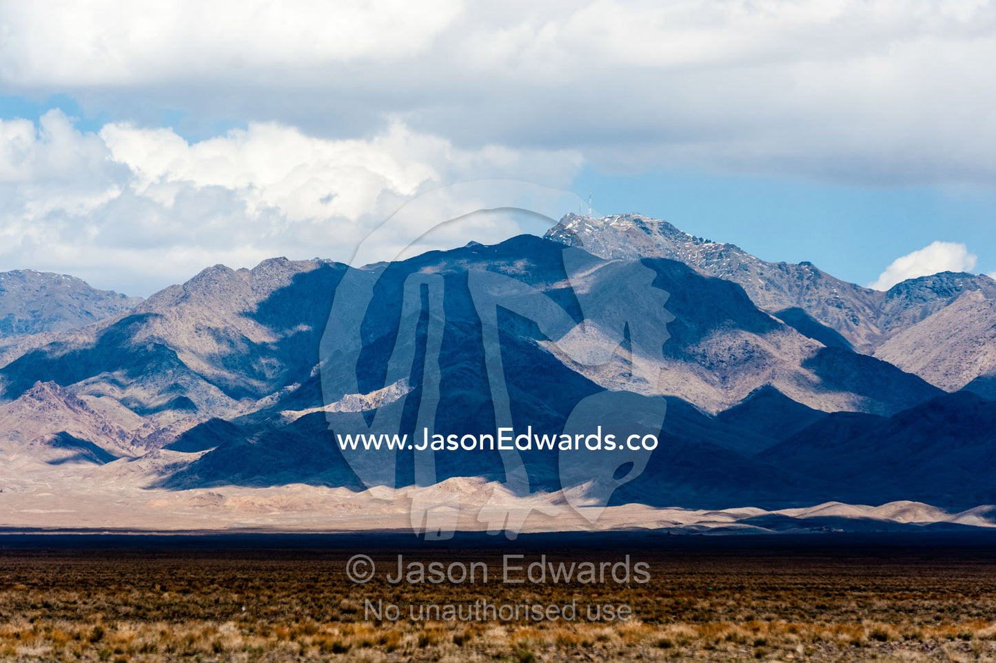 Cloud shadows on a rugged mountain in the desert. Road to Nain, Nain County, Isfahan Province, Iran.