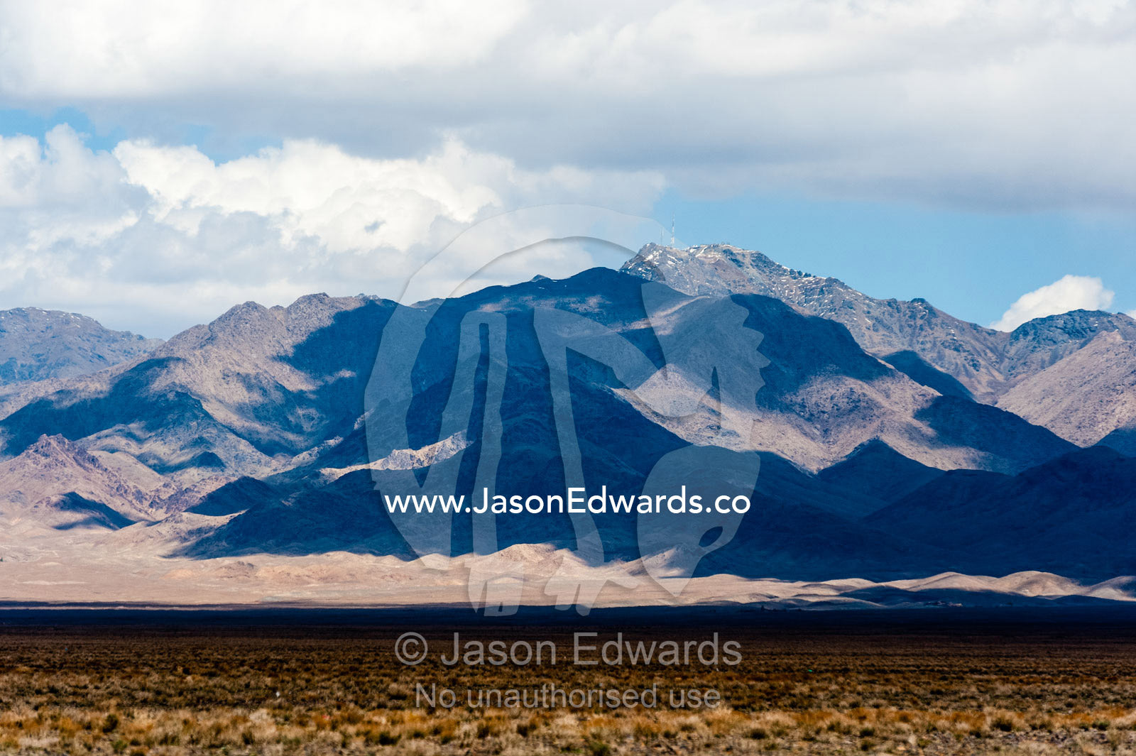Cloud shadows on a rugged mountain in the desert. Road to Nain, Nain County, Isfahan Province, Iran.