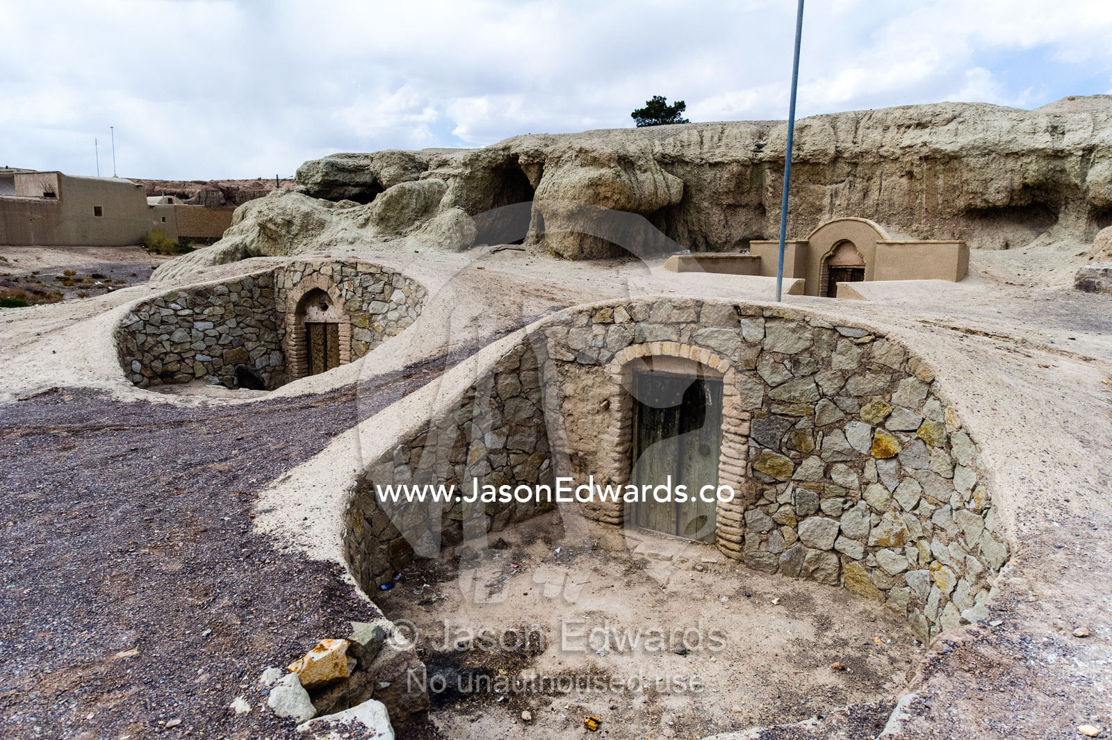 The stone facades of traditional cloak weaving workshops buried underground in the desert. Nain, Nain County, Isfahan Province, Iran.