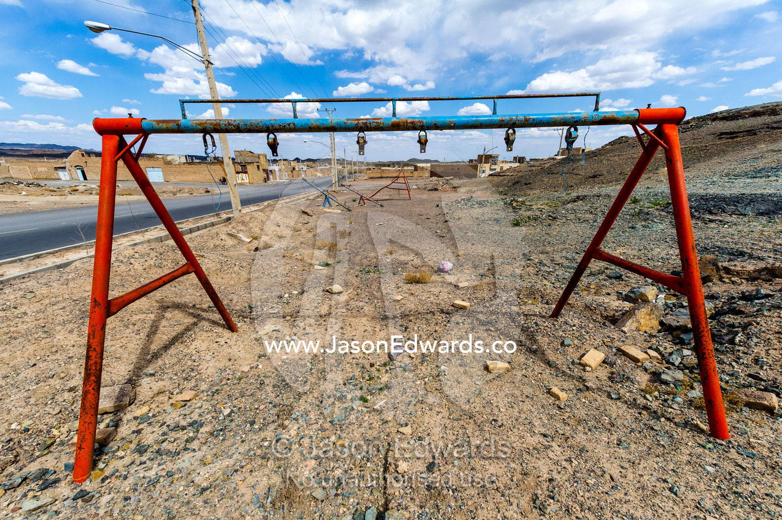 A derelict swing and playground equipment in a desert village. Nain, Nain County, Isfahan Province, Iran.