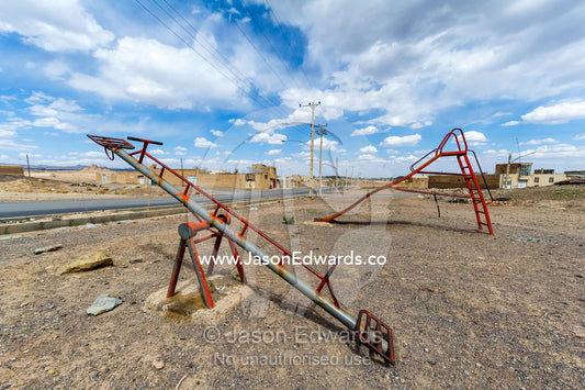 A derelict slide and seesaw in a desert village. Nain, Nain County, Isfahan Province, Iran.