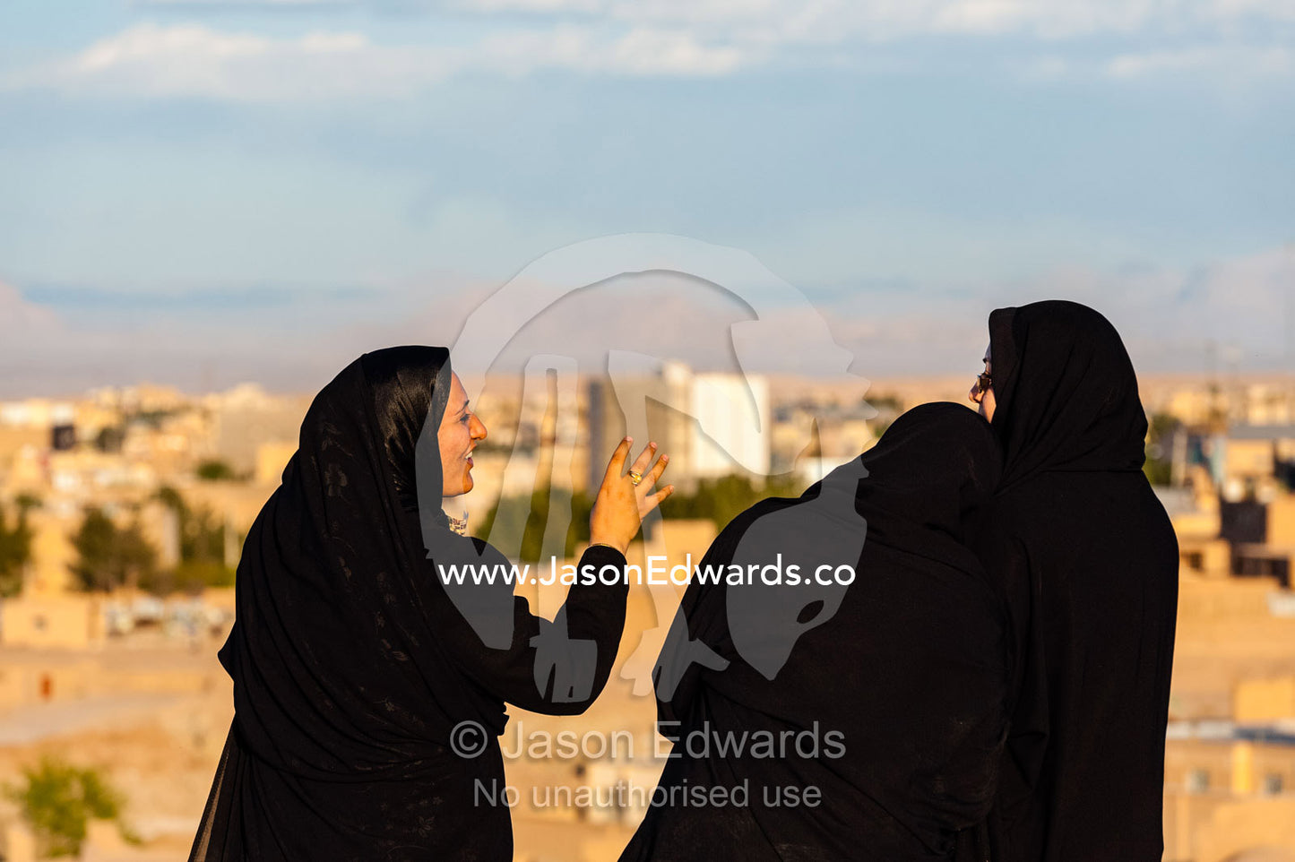Women laughing and talking on the rooftop of an ancient fortress in the desert. Narin Castle, Meybod, Meybod County, Yazd Province, Islamic Republic of Iran.
