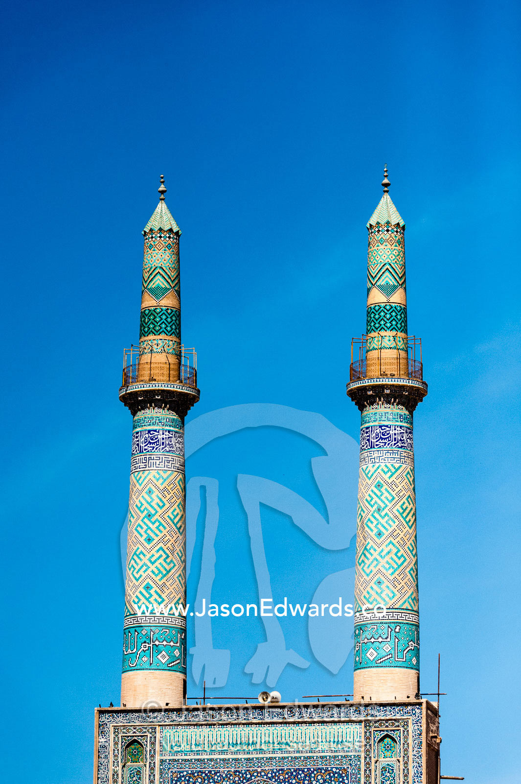 The twin tiled minarets of the Jame Mosque against a blue sky. Jame Mosque of Yazd, Yazd, Yazd Province, Islamic Republic of Iran.