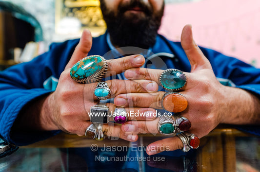 A merchant displays his silver and precious stone rings he sells in a bazaar. Yazd, Yazd Province, Islamic Republic of Iran.