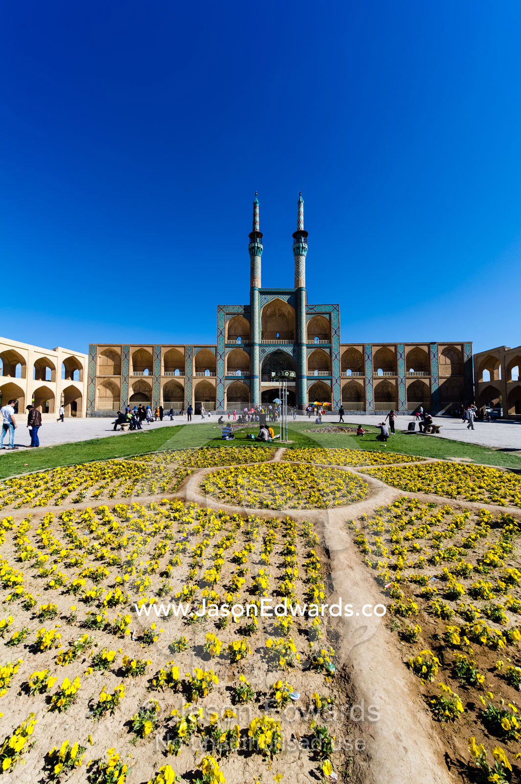 The towering minarets and iwans of Amir Chakhmaq Mosque overlook flower gardens in the square. Amir Chakhmaq Square, Yazd, Yazd Province, Islamic Republic of Iran.