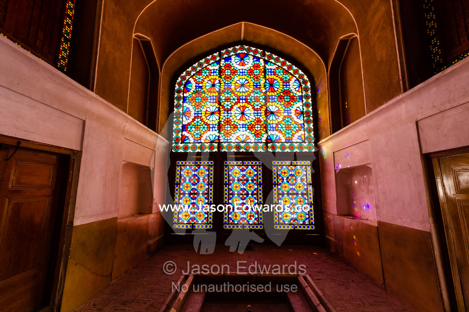 Sunlight pours through colourful stained glass windows lighting the interior of the residence. Dowlat Abad Garden, Yazd, Yazd Province, Islamic Republic of Iran.