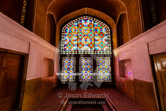 Sunlight pours through colourful stained glass windows lighting the interior of the residence. Dowlat Abad Garden, Yazd, Yazd Province, Islamic Republic of Iran.