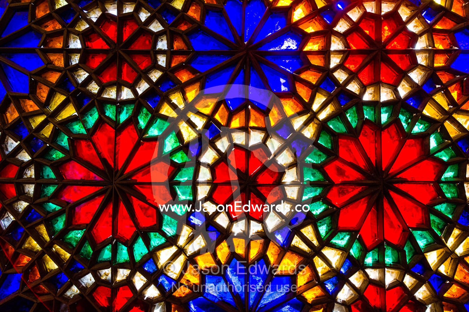 Sunlight pours through colourful stained glass windows lighting the interior of the residence. Dowlat Abad Garden, Yazd, Yazd Province, Islamic Republic of Iran.