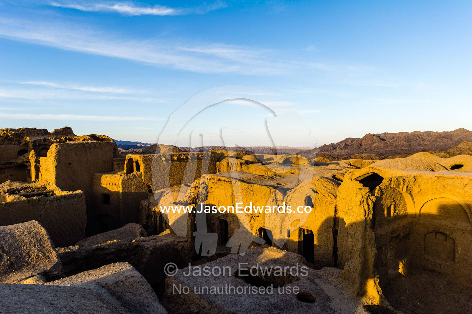 Looking across the rooftops of crumbling handmade brick ruins of an ancient abandoned village in the desert. Kharanagh, Yazd, Yazd Province, Islamic Republic of Iran.