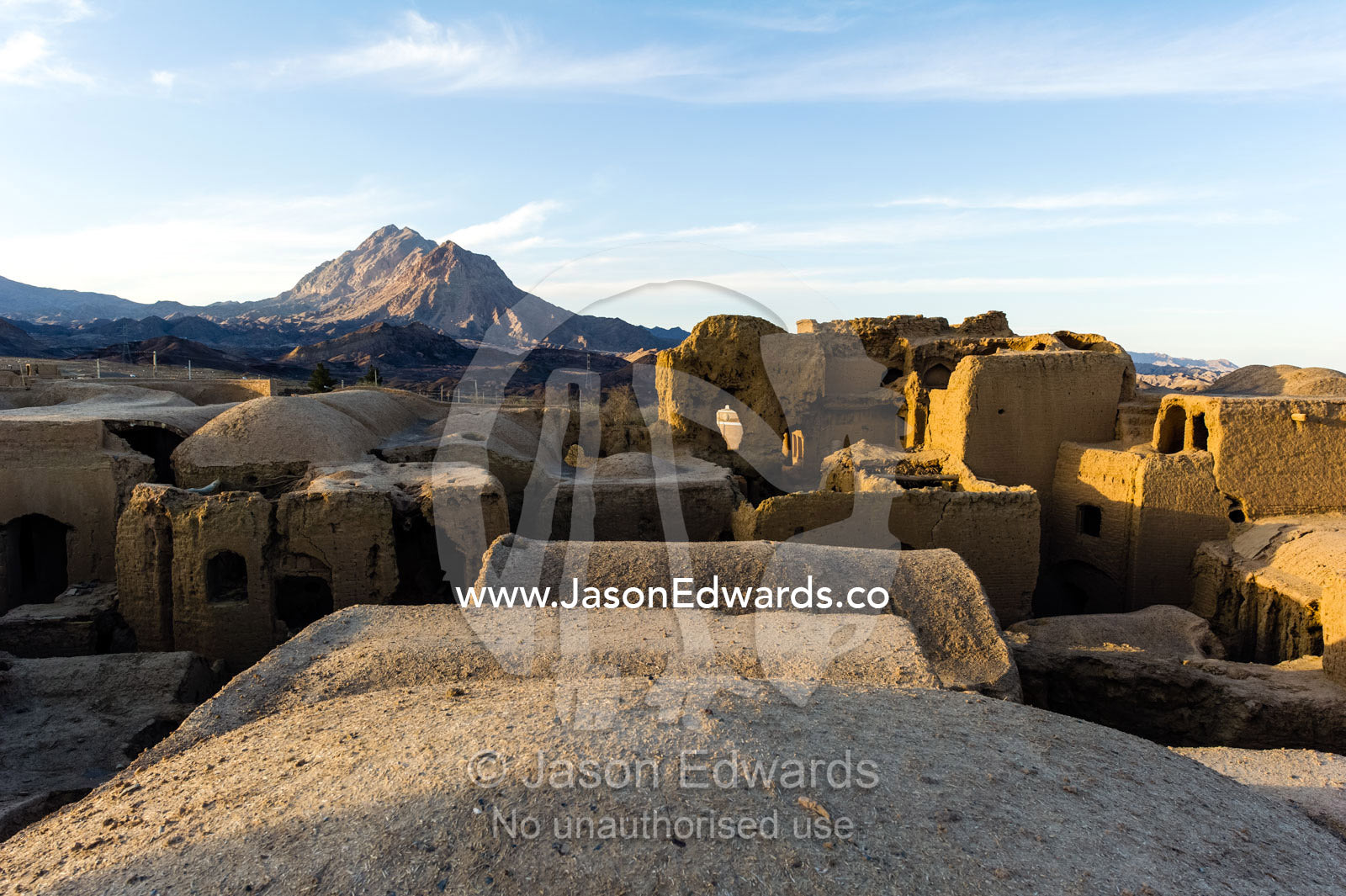 Looking across the rooftops of crumbling handmade brick ruins of an ancient abandoned village in the desert. Kharanagh, Yazd, Yazd Province, Islamic Republic of Iran.
