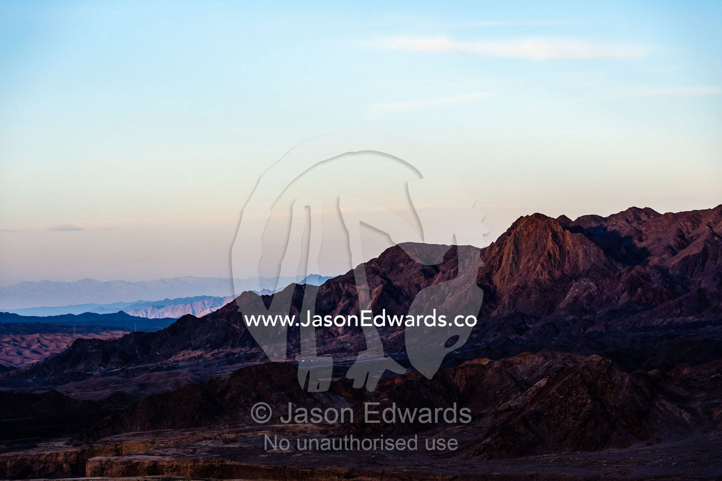 Sunset afterglow over jagged desert mountains and valleys. Kharanagh, Yazd, Yazd Province, Islamic Republic of Iran.