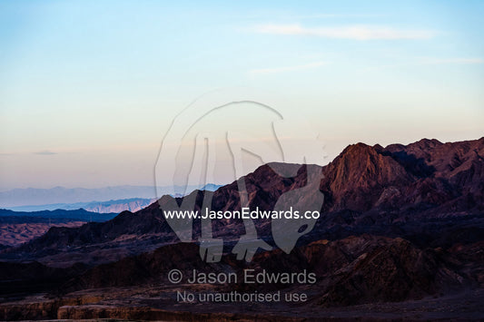 Sunset afterglow over jagged desert mountains and valleys. Kharanagh, Yazd, Yazd Province, Islamic Republic of Iran.