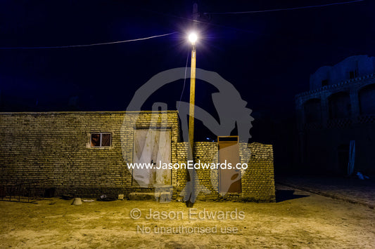 A streetlight illuminates a small brick house in a village. Kharanagh, Yazd, Yazd Province, Islamic Republic of Iran.