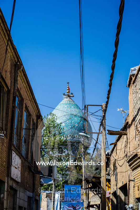 Electricity cables running above a narrow street leading to a mosque. Shiraz, Fars Province, Islamic Republic of Iran.