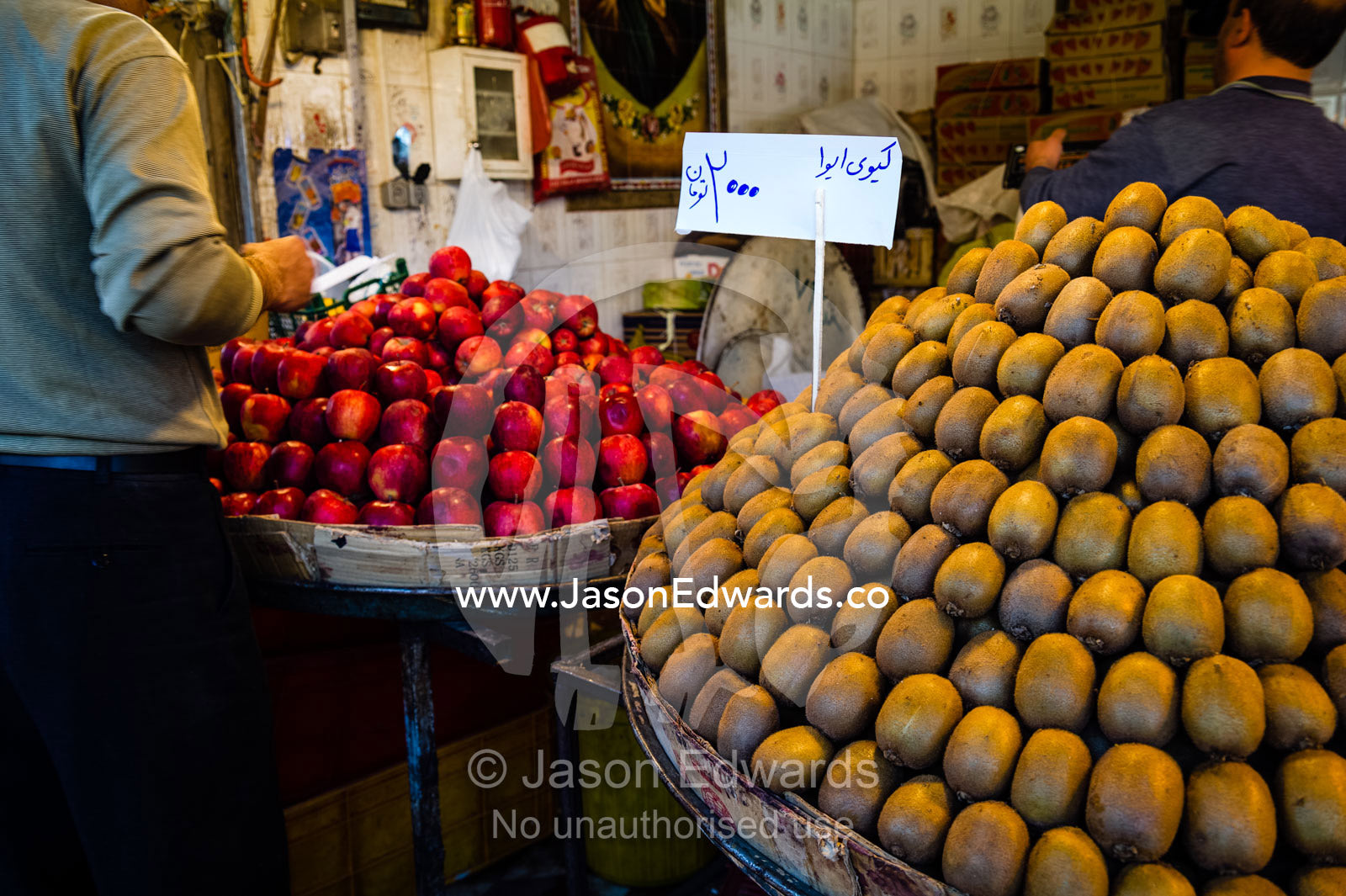 Rows of neatly stacked kiwi fruit and red apples for sale in a fresh food market. Shiraz, Fars Province, Islamic Republic of Iran.