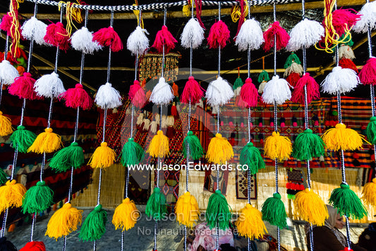 Colourful tassles hanging from a bedouin stall in a market celebrating Nowruz Iranian New Year. Tomb of Hafez, Shiraz, Fars Province, Islamic Republic of Iran.