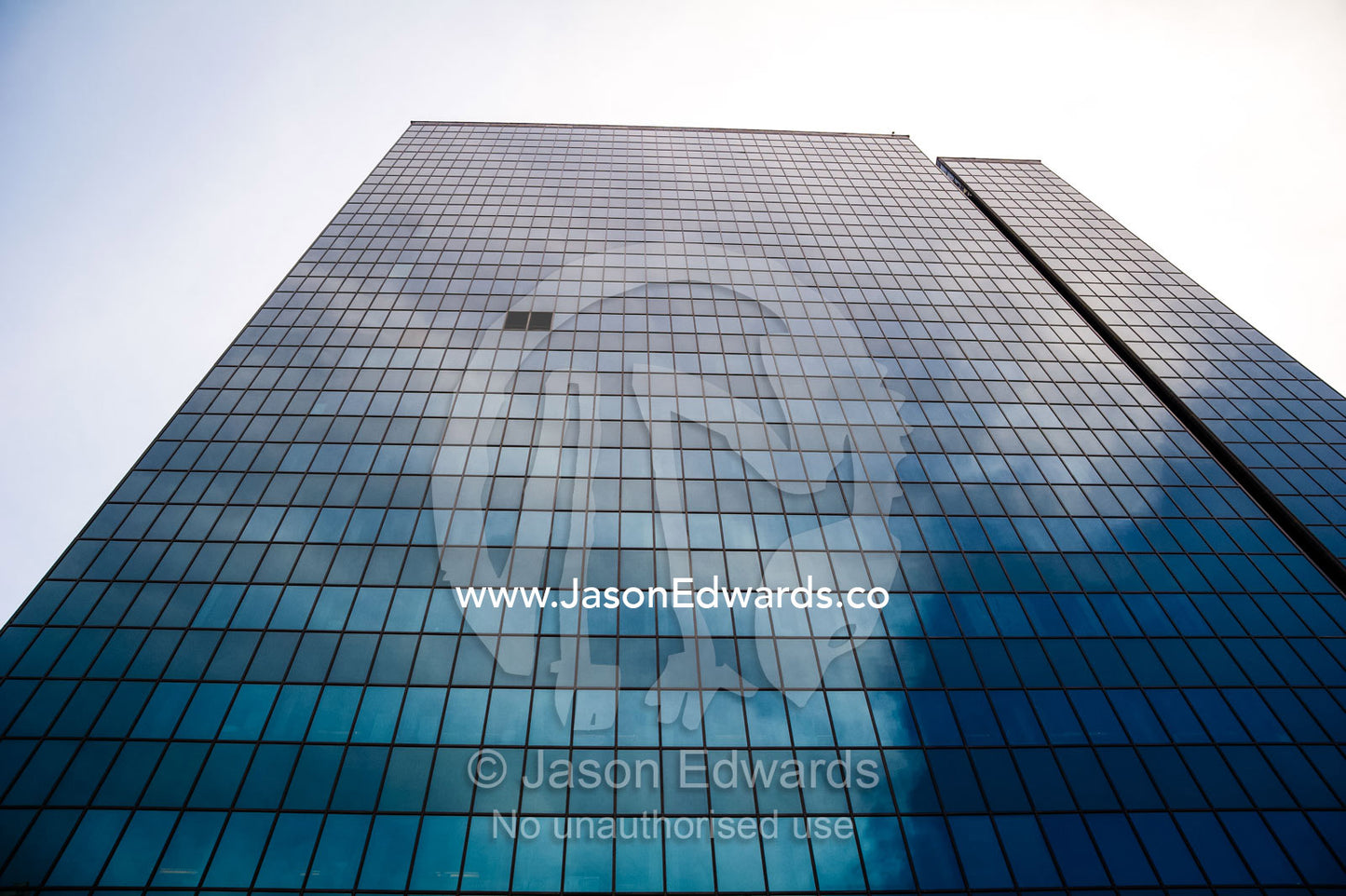 Clouds reflecting off the steel and glass facade of a banking office in Tehran. Tehran, Tehran Province, Islamic Republic of Iran.