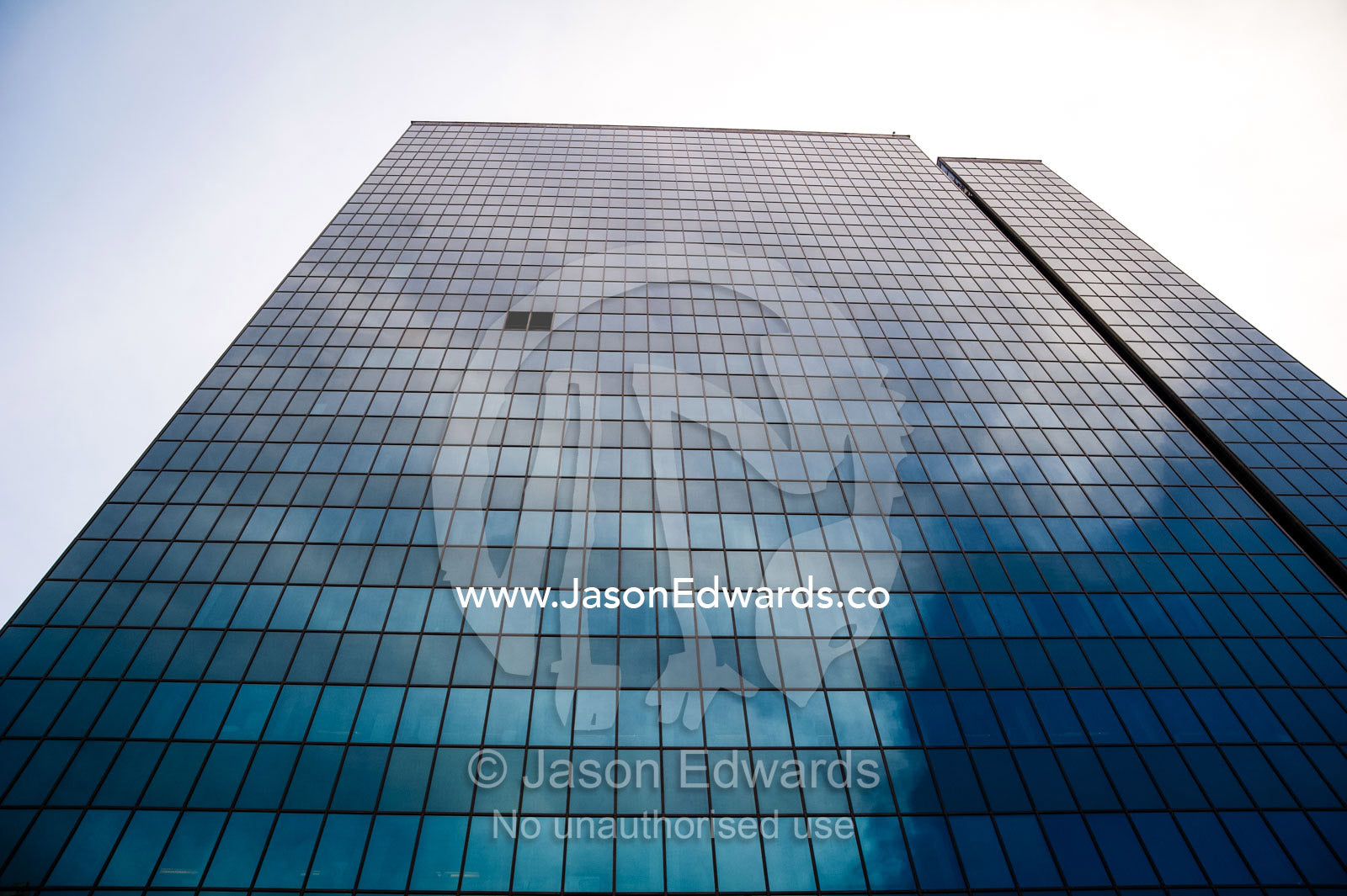 Clouds reflecting off the steel and glass facade of a banking office in Tehran. Tehran, Tehran Province, Islamic Republic of Iran.