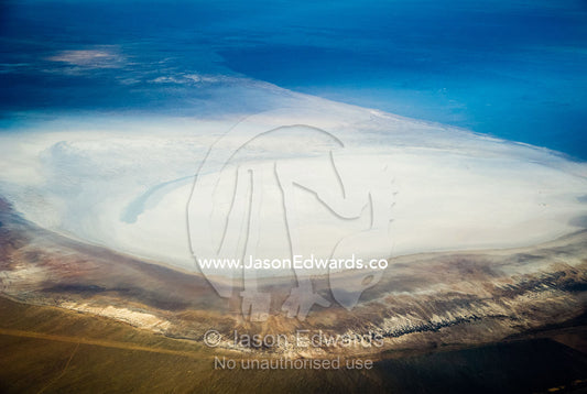 A high altitude view of sunrays lighting a salt lake in the desert. Islamic Republic of Iran.