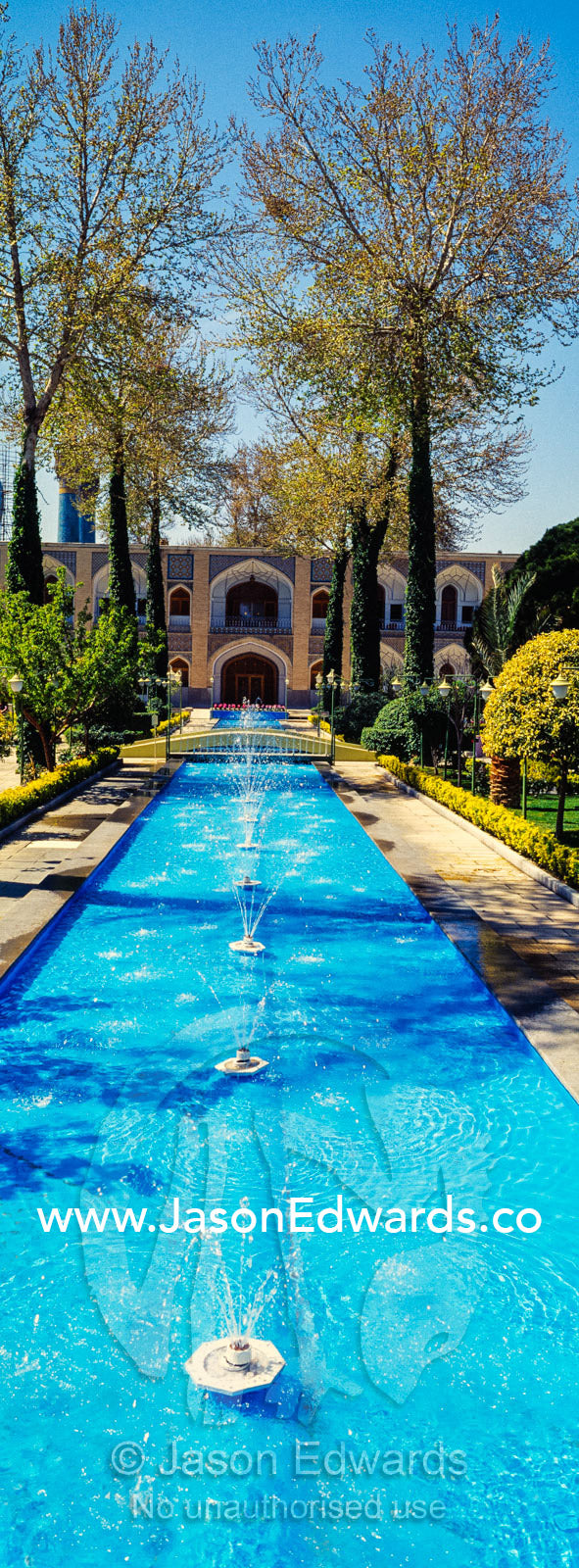 An ornamental pond with fountains and traditional garden in a caravanserai converted into a boutique hotel. The Abbasi Hotel, Isfahan, Isfahan Province, Islamic Republic of Iran.