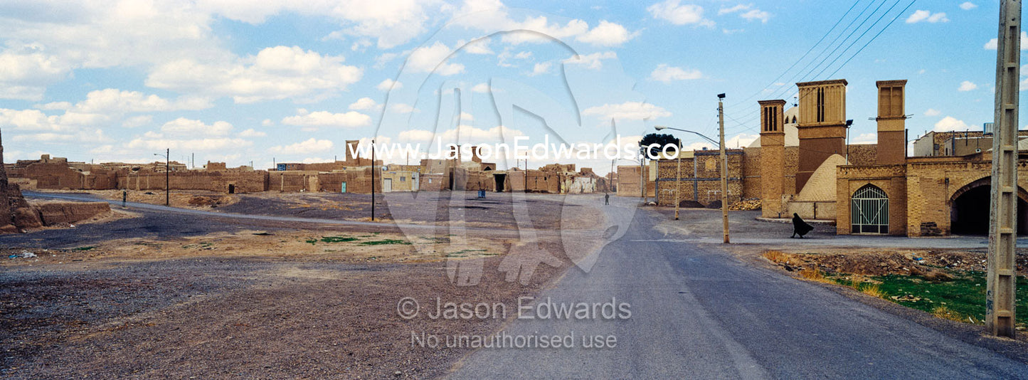 An empty road passing through a deserted village beneath windcatchers. Nain, Nain County, Isfahan Province, Islamic Republic of Iran.