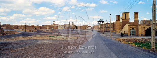 An empty road passing through a deserted village beneath windcatchers. Nain, Nain County, Isfahan Province, Islamic Republic of Iran.