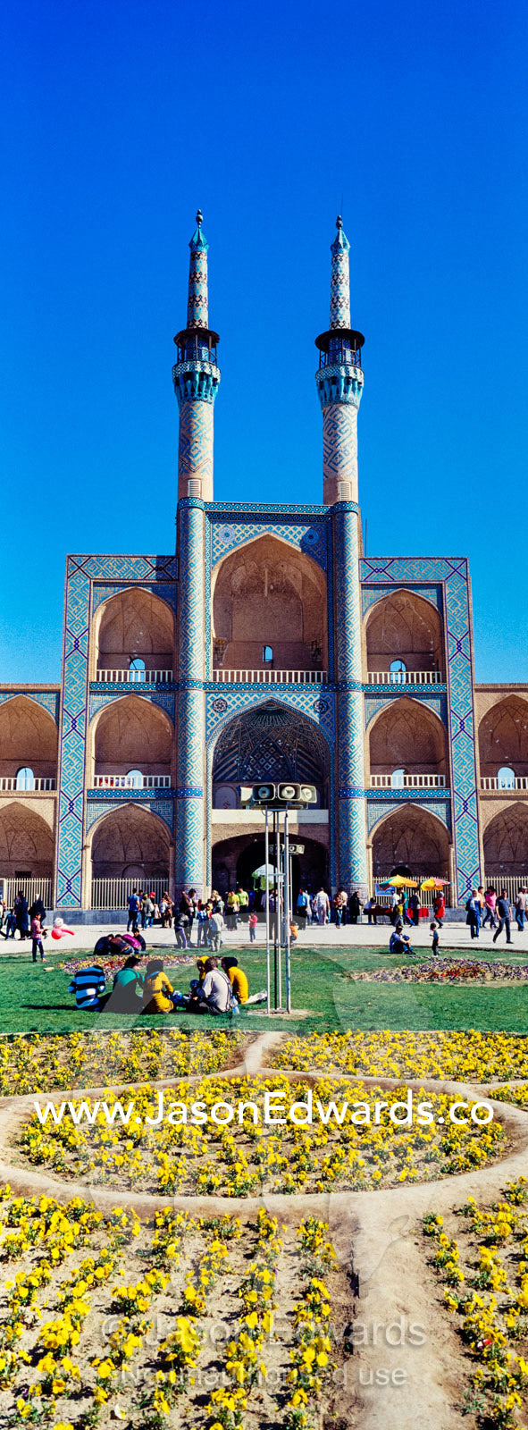 The towering minarets and iwans of Amir Chakhmaq Mosque overlook flower gardens in the square. Amir Chakhmaq Square, Yazd, Yazd Province, Islamic Republic of Iran.