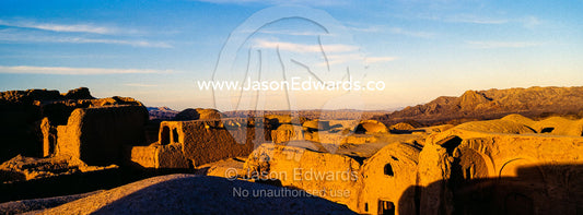 Looking across the rooftops of crumbling handmade brick ruins of an ancient abandoned village in the desert. Kharanagh, Yazd, Yazd Province, Islamic Republic of Iran.