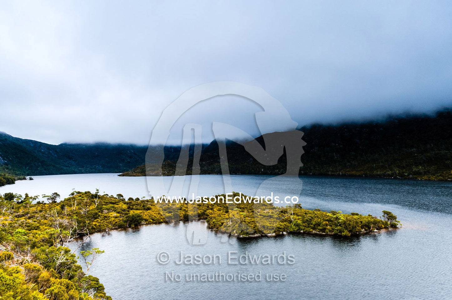 A storm descends over the forested slopes of an alpine glacial lake. Cradle Mountain, Lake St Clair National Park, Tasmania, Australia.