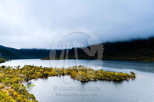 A storm descends over the forested slopes of an alpine glacial lake. Cradle Mountain, Lake St Clair National Park, Tasmania, Australia.