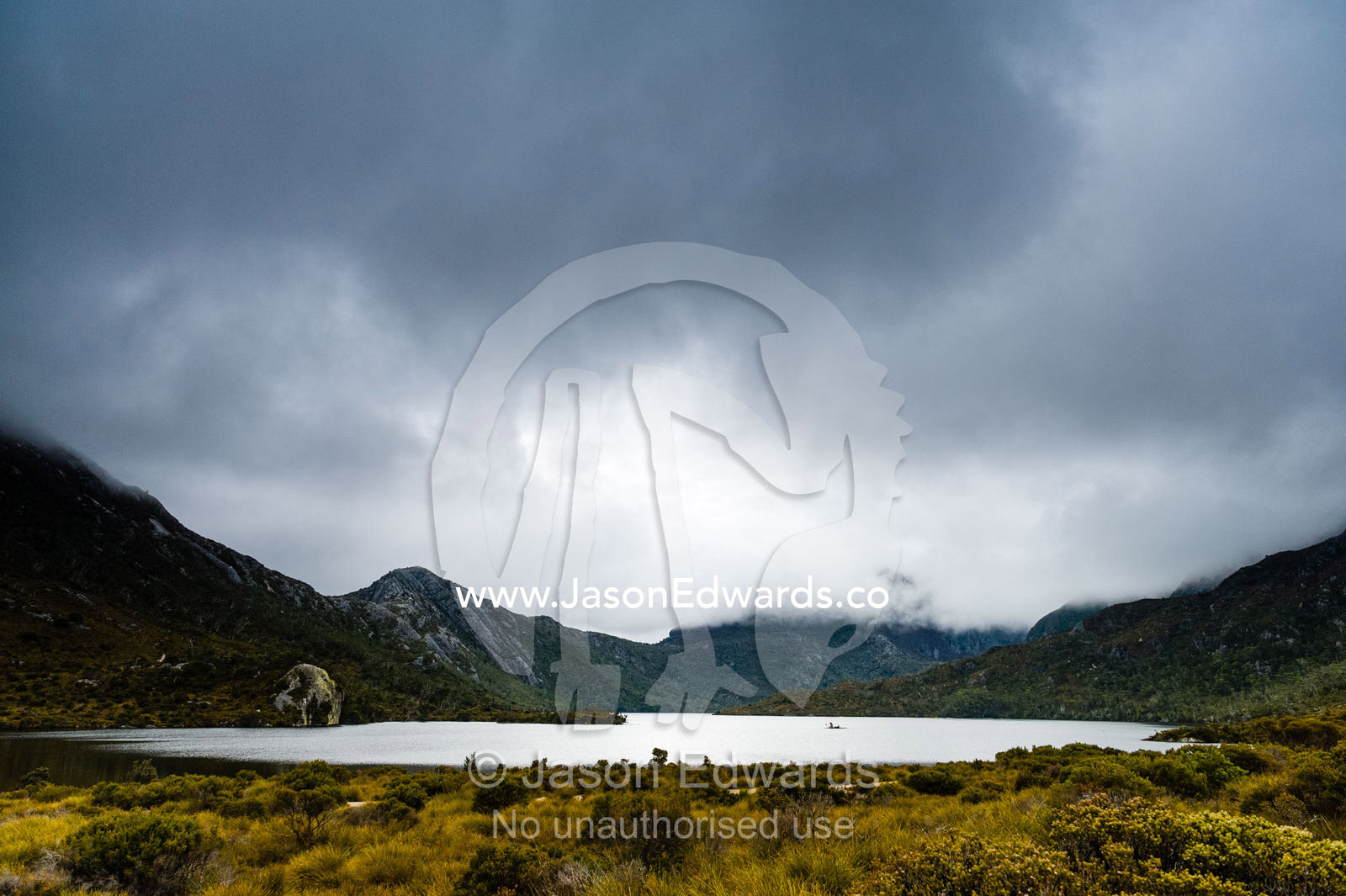 A storm descends over the forested slopes of an alpine glacial lake. Cradle Mountain, Lake St Clair National Park, Tasmania, Australia.