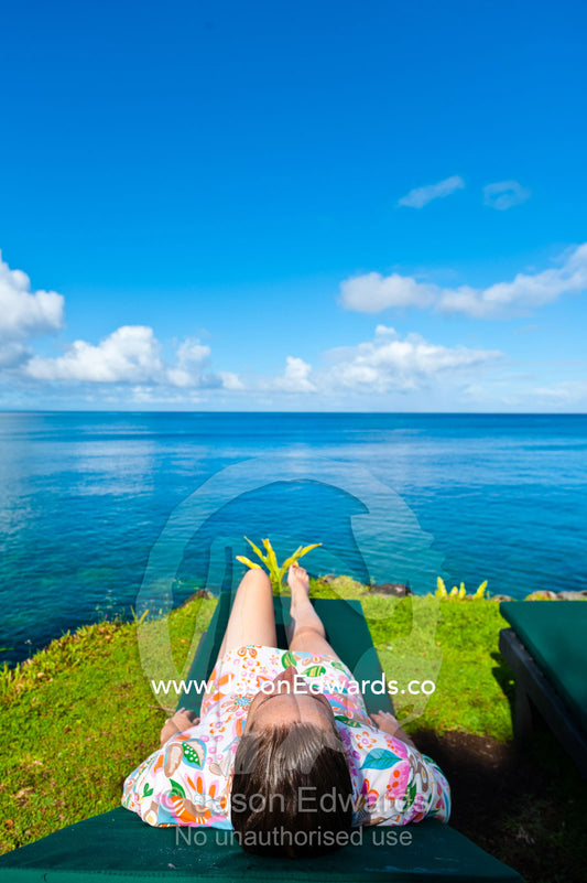 A woman relaxing on a sunbed on a tropical island. Taveuni Island, Somosomo Strait, Pacific Ocean, Fiji Islands.