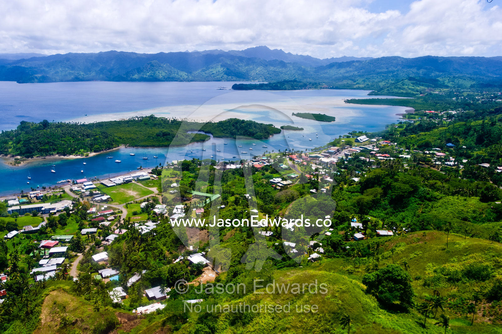 An aerial view of a small village on a tropical island. Taveuni Island, Somosomo Strait, Pacific Ocean, Fiji Islands.