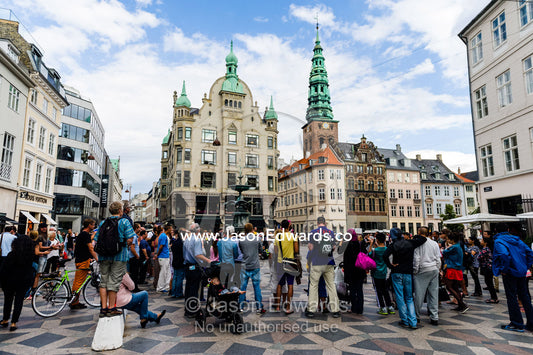 Crowds gather in Amagertorv central square in Copenhagen to watch street performers. Amagertorv Central Square, Copenhagen, Denmark.