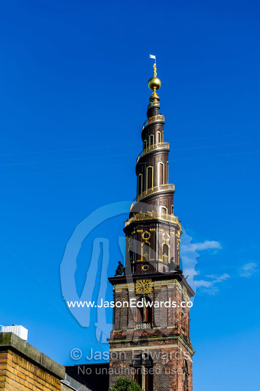 The spiral spire of the Church of Our Saviour rising into a blue sky. The Church of Our Saviour, Copenhagen, Denmark.