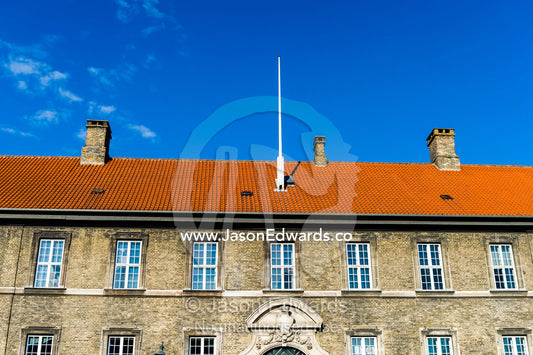 An orange tiled rooftop beneath a blue sky in Copenhagen. Frederiksholms Canal, Copenhagen, Denmark.
