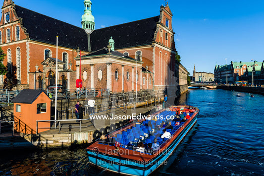 A canal boat with tourists moors beside the Holmen Church in Copenhagen. Holmen Church, Copenhagen, Denmark.