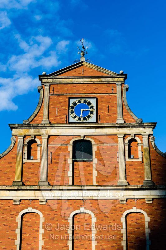 An antique clock tower and brick facade on the Holmen Church. Holmen Church, Copenhagen, Denmark.