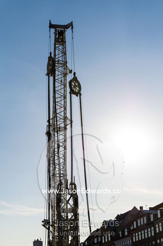 The silhouette of a pile driver on a city construction site. Copenhagen, Denmark.