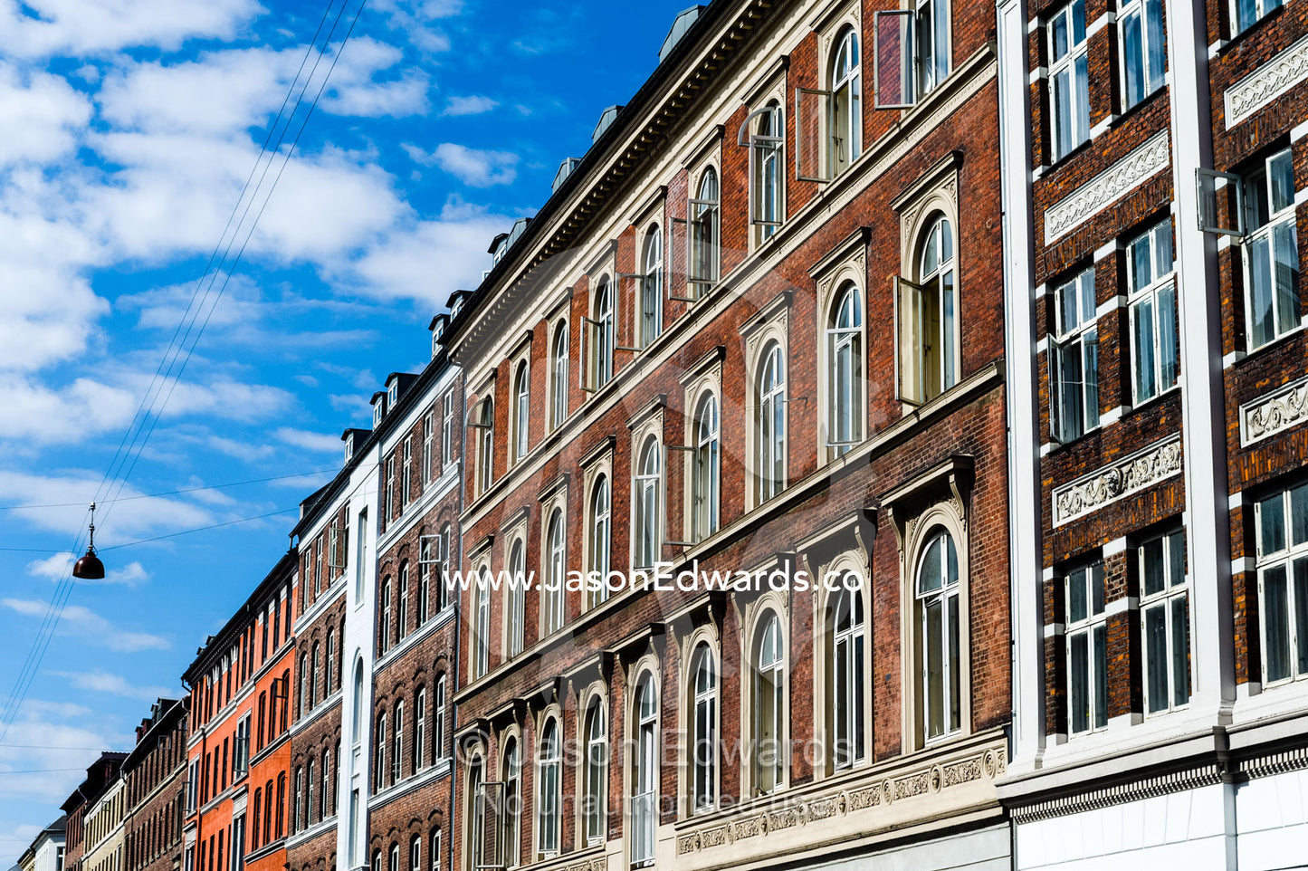 The colourful facades and windows of houses and apartments lining a road in Copenhagen. Copenhagen, Denmark.