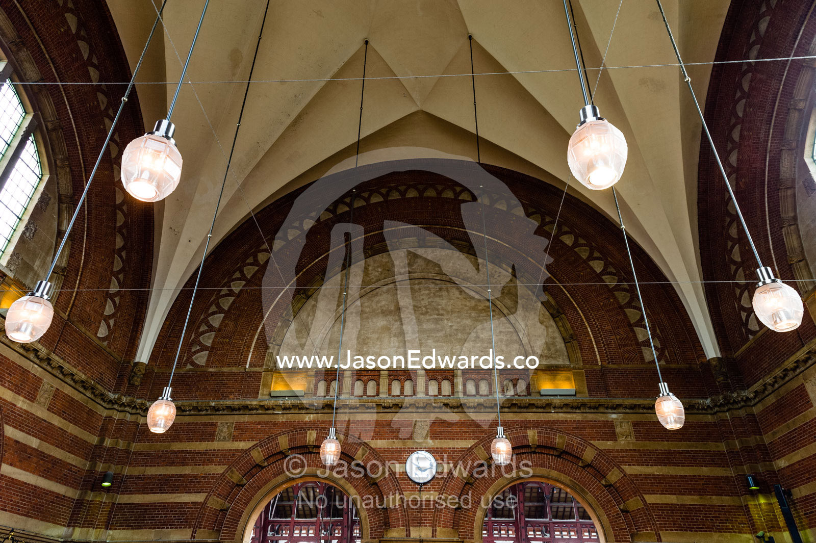 The domed ceiling and suspended lights of a train station. Copenhagen Central Train Station, Copenhagen, Denmark.